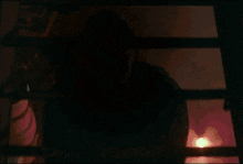 a man in a mask is standing in front of a window