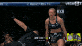 a woman in a ufc top stands in a cage