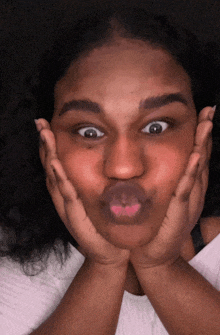 a woman making a face with her hands on her face