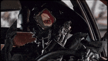 a person wearing a helmet and goggles is driving a car