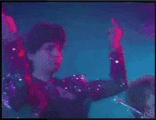 a man in a sequined jacket is giving a middle finger