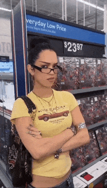 a woman wearing glasses is standing in front of a sign that says everyday low price