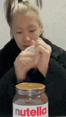 a person is opening a jar of nutella