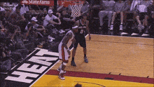 a basketball game is being played in front of a state farm advertisement