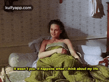 a woman is laying on a bed with a green blanket and a quote .