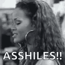 a black and white photo of a woman with hoop earrings and the words `` assholes ! ''