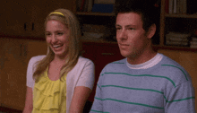 a man and a woman are sitting next to each other smiling