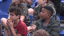 a group of children are sitting in a stadium watching a sporting event