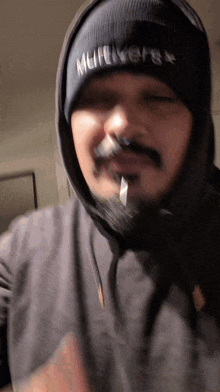 a man wearing a black beanie that says mufflers on it