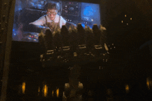 a screen shows a man in an apron holding a cocktail