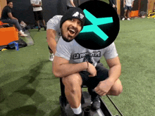 a man wearing a lb prototype shirt sits on a sled