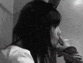 a woman smoking a cigarette in a black and white image
