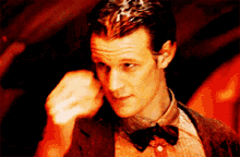 a close up of a man wearing a bow tie and a suit