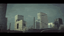 a car is parked in front of a city skyline with lots of tall buildings