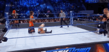 a wrestler is laying on the floor in a wrestling ring while a referee walks around