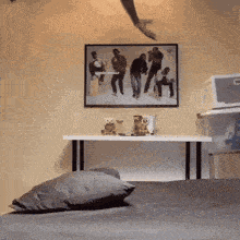 a picture of a group of people is hanging on a wall above a pillow
