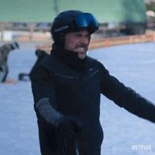 a man wearing a smith helmet and goggles stands in the snow with his arms outstretched