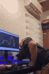 a man is doing push ups in front of a computer screen with a graph on it