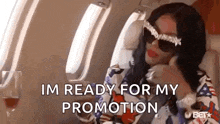 a woman is sitting on an airplane talking on a cell phone and ready for her promotion .