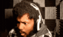 a man with a beard is wearing headphones and making a face .