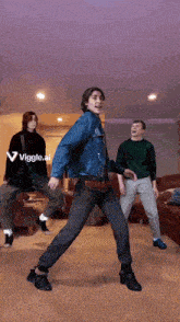 a group of young men are dancing in a living room with the words " viggle.ai " in the corner