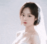 a woman in a white dress and veil is looking at the camera