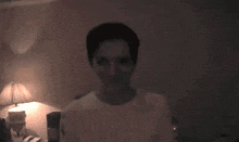 a man is looking at the camera in a dark room .