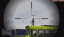 a sniper scope shows a man standing on top of a yellow bus with vanoss gaming written on the bottom