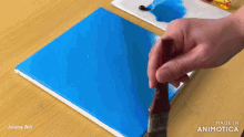 a person is painting a blue square with a brush and the words made in animotica are visible