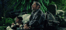 a man in a wheelchair sits next to a little girl in a wheelchair