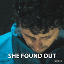 a man in a blue jacket with the words she found out written below him