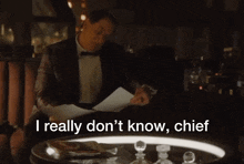 a man in a tuxedo sits at a table and says i really don t know chief
