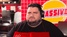 a man wearing headphones and an apron that says go massive