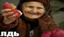 an elderly woman is smiling while holding an apple in her hand .