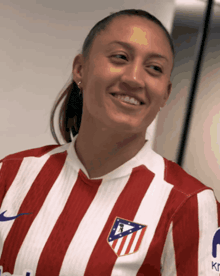 a woman wearing a red and white striped shirt with the letter a on the front