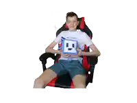 a boy is sitting in a chair holding a pillow that says playstation