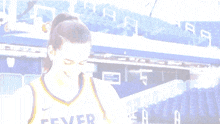 a female basketball player wearing a fever jersey