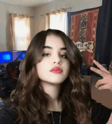 a young woman is taking a selfie in a room with a sign that says peace .
