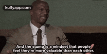 a man in a suit and tie is talking about a mindset that people have .