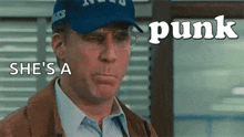 a man wearing a blue hat and glasses is talking about a woman .