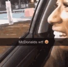a woman is sitting in a car with a mcdonald 's wtf snapchat on her face .