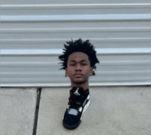 a man 's head is cut out of a black shoe