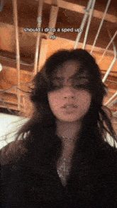 a woman with long dark hair is standing in front of a wooden ceiling and says should i drop a sped up ep