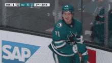 a hockey player with the number 11 on his jersey stands on the ice