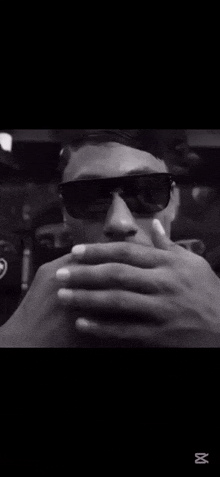 a black and white photo of a person taking a picture of another person with their hands .