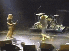 a man playing a guitar and a man playing drums on a stage