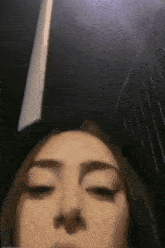 a close up of a woman 's face with her eyes closed in a dark room .