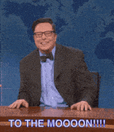 a man sitting at a desk with the words to the moooon written on the bottom