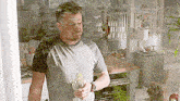 a man is standing in a kitchen holding a glass of wine