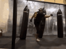 a man is kicking a punching bag in a boxing gym